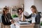 Senior couple buying groceries in zero waste shop, sales assistants serving them.