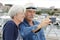 Senior couple with camera taking selfie in port