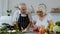 Senior couple cooking salad with vegetables. Woman dancing holding fresh slices of pepper on eyes