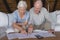 Senior couple discussing over medical bills in living room