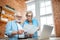 Senior couple with documents and laptop at home