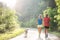 Senior couple with dog running in green sunny nature