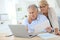 Senior couple doing paperwork in laptop