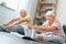 Senior couple doing yoga together at home health care legs stretching
