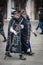 A senior couple dressed in black carnival dress walks down the street during Venetian carnival