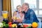 Senior couple drinking vegan smoothie with organic fruits and vegatables from eco glasses and reusable tubes