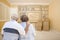 Senior Couple In Empty Room with Shelf Drawing on Wall