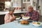 Senior Couple Enjoying Meal Around Table At Home