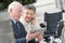 Senior couple enjoying modern technology using tablet and cellphone