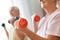 Senior couple exercise together at home health care dumbbells close-up