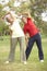 Senior Couple Exercising In Park