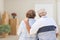 Senior Couple Facing Empty Room with Packed Moving Boxes and Pot