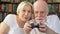 Senior couple gamers playing video game at home. Players with remote controller of game console