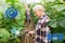 Senior couple with garden hose at farm greenhouse