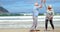 Senior couple giving high five on beach