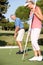 Senior Couple Golfing On Golf Course