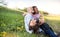 Senior couple with grandaughter outside in spring nature, relaxing on the grass.