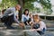 Senior couple with grandchildren drawing with chalks on pavement outdoors in park.