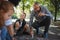 Senior couple with grandchildren drawing with chalks on pavement outdoors in park.