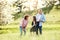 Senior couple with granddaughter outside in spring nature, having fun.