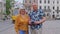 Senior couple grandmother grandfather tourists talking on city street, holidays vacation traveling