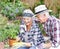 Senior couple, happiness and plant in garden for love, environment and sustainability in home. Man, woman and flowers