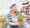 Senior couple, happy and plant in garden for love, environment and sustainability in home. Man, woman and flowers