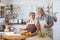 Senior couple having fun in kitchen with healthy food - Retired people cooking meal at home with man and woman preparing lunch