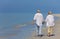 Senior Couple Holding Hands Walking on Beach