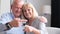 Senior couple holding the keys to a new house. Happy pensioners in their home.