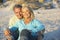 Senior Couple On Holiday Sitting On Sandy Beach