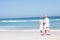 Senior Couple On Holiday Walking Along Sandy Beach