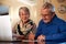 Senior Couple At Home Checking Personal Finances On Laptop