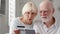 Senior couple at home. Shopping with credit card on smartphone. Active modern life after retirement