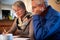 Senior Couple At Home Sitting At Table Checking Personal Finances