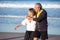 Senior couple hugging on seashore and looking to side