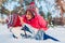 Senior couple hugging in winter forest. Man and woman lying in snow and having fun on Valentine`s Day