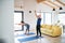 A senior couple indoors at home, doing exercise in living room.