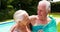 Senior couple kissing each other in the poolside