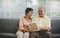 Senior couple is looking at memory photo on a couch at home for happy retirement lifestyle concept