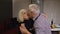 Senior couple in love have romantic evening, dancing together in kitchen, celebrating anniversary