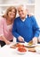 Senior Couple Making Sandwich In Kitchen