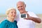 Senior couple making self photo on the beach