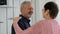 Senior couple, mature man and elderly woman dancing in the kitchen