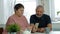 Senior couple, mature man and elderly woman looking at smartphone, video call