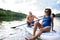 Senior couple paddleboarding on lake in summer.