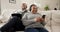 Senior couple, phone and laptop with headphones on sofa, streaming music and social media for happy by technology