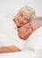 Senior couple, portrait and together in bed, relaxing and love in retirement for bonding on weekend. Elderly people