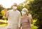 Senior couple in protective medical masks at park