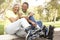 Senior Couple Putting On In Line Skates In Park